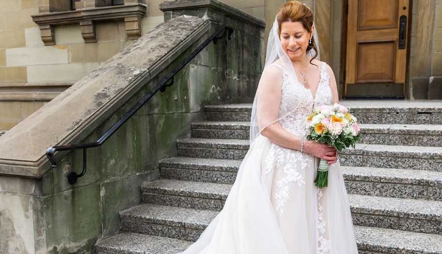 bride with bouquet in front of building