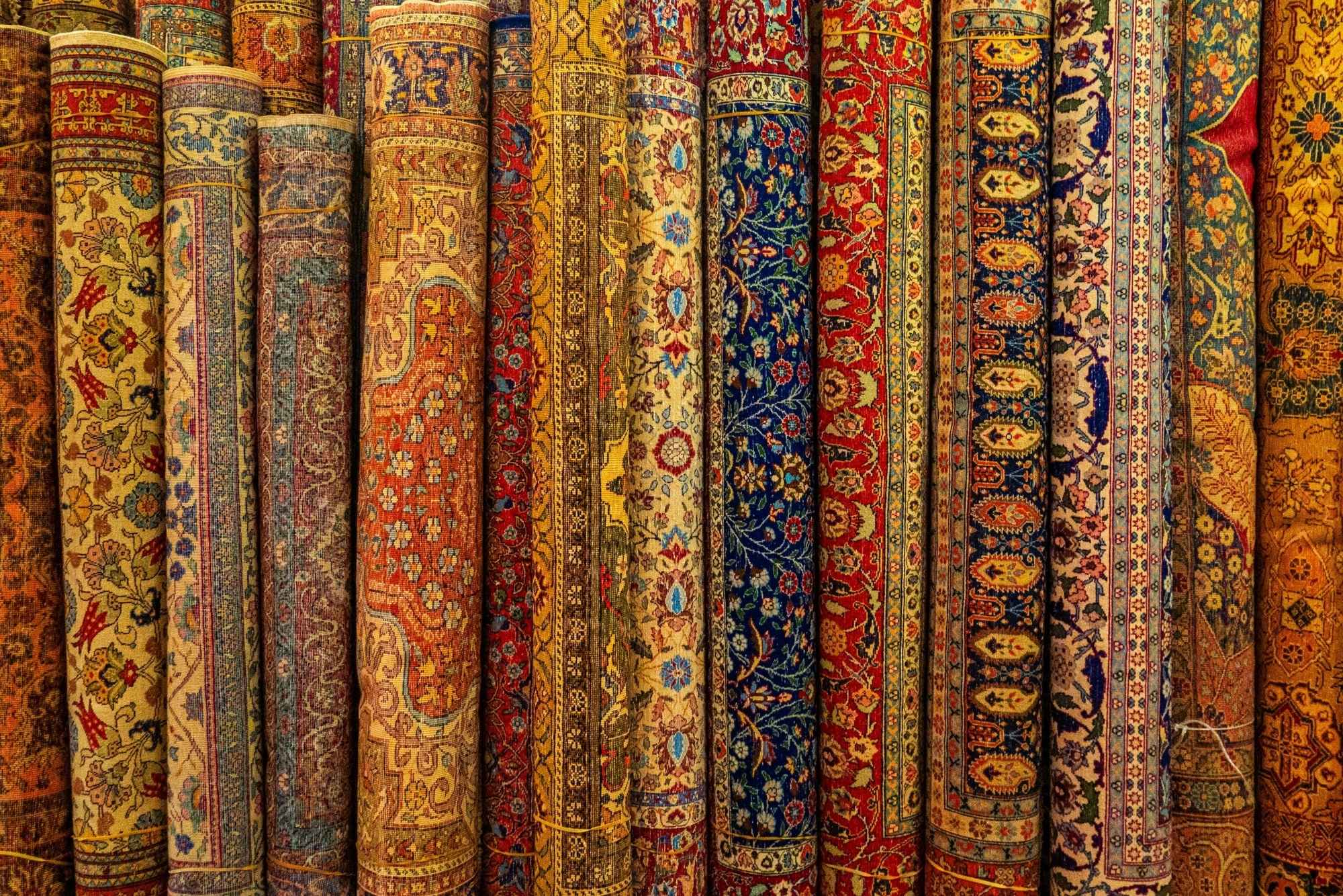 Several rolled-up oriental rugs displayed side by side
