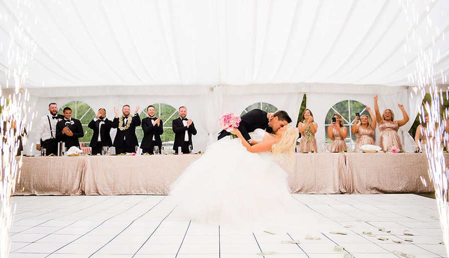 bride and groom with wedding party cheering