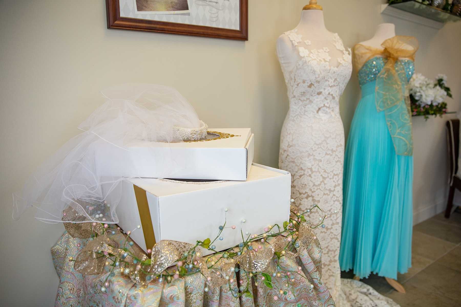 two wedding dresses on mannequins next to paper boxes