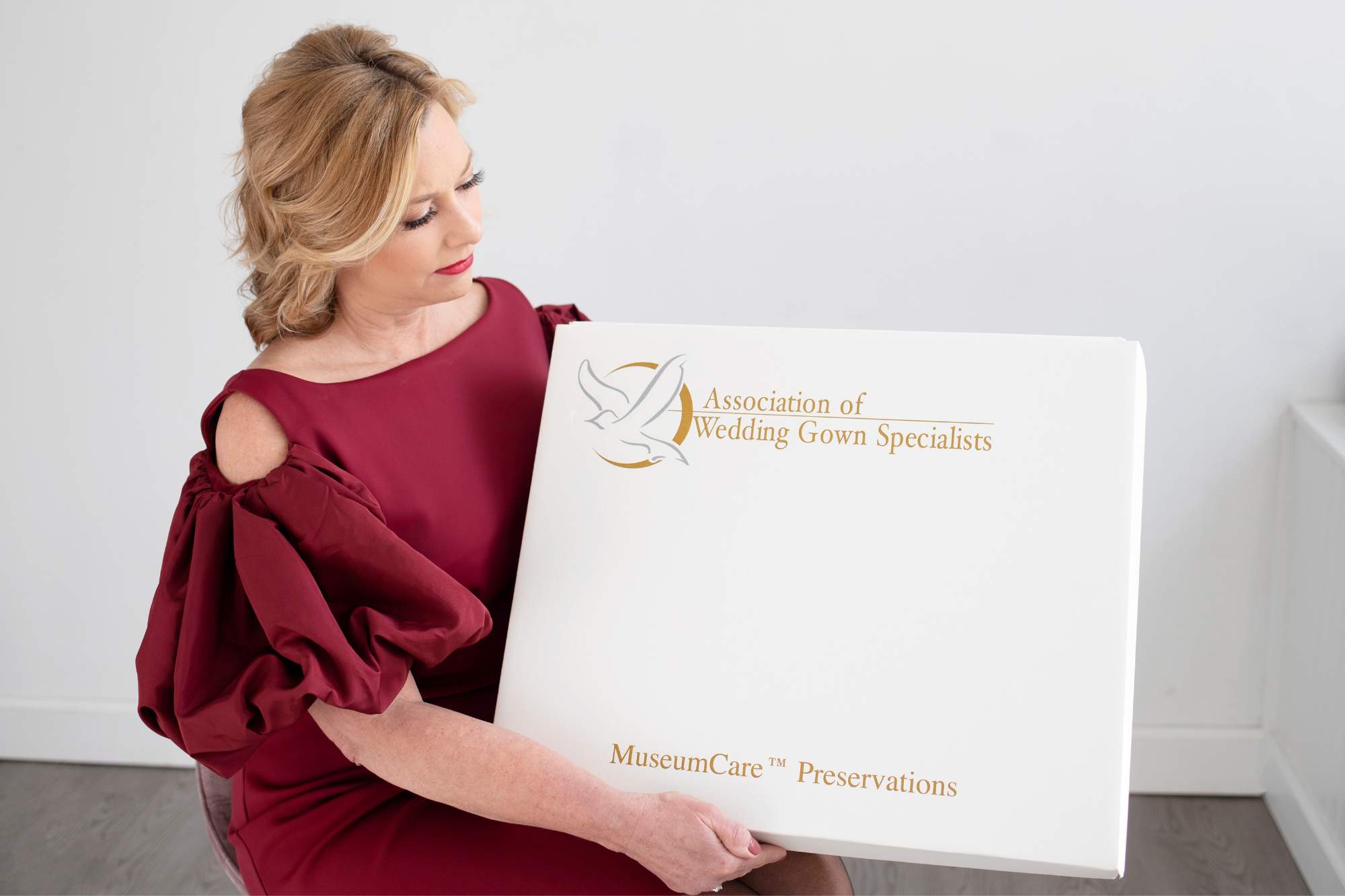 heather holding an association of wedding gown specialists box