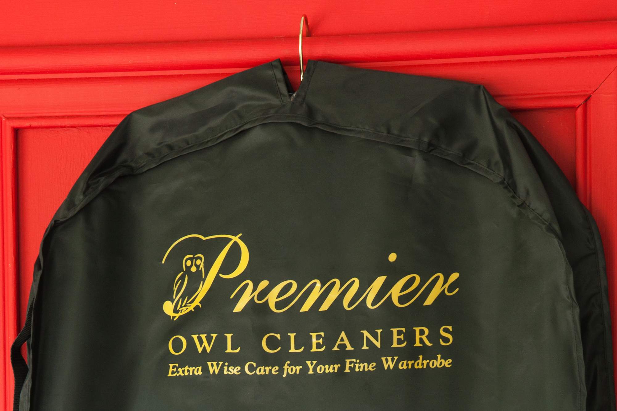 owl cleaners bag hanging on red door